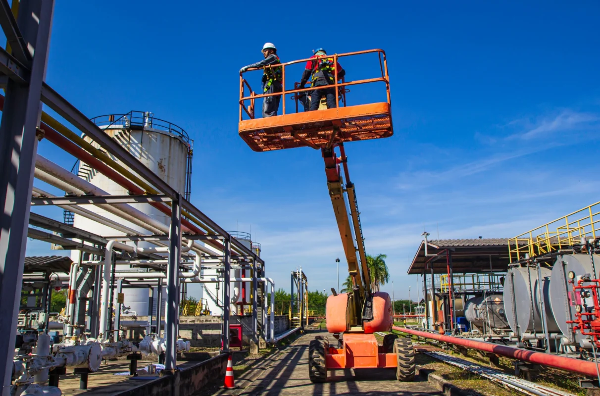 podest ruchomy z dwoma pracownikami stojącymi w koszu na składowisku