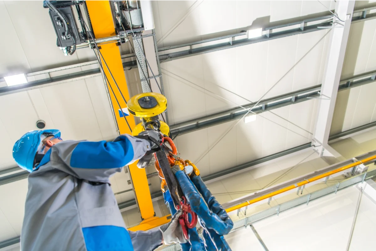 Kursant BEHAP-BUD obsługuje suwnicę w hali przemysłowej podczas szkolenia UDT z obsługi suwnic.